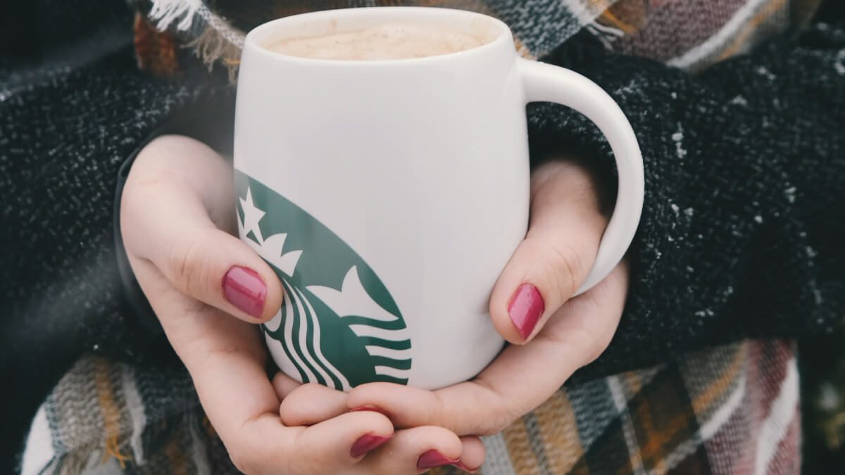 cold hands holding starbucks cup thinking about blog writing in the winter