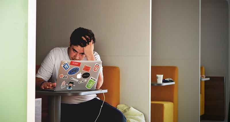 man stressed out working on his laptop