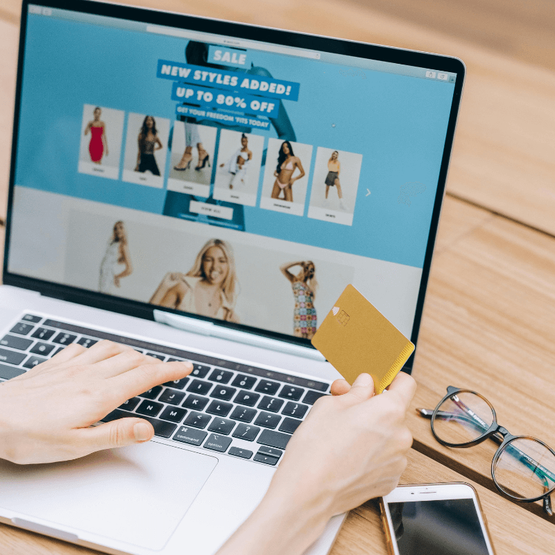 person-using-laptop-while-holding-a-credit-card